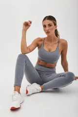 Top deportivo gris con espalda cruzada de doble tira y almohadillas removibles.