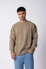 Sweater de punto grueso en color verde oliva, con diseño oversized, cuello redondo y mangas largas con puños acanalados.