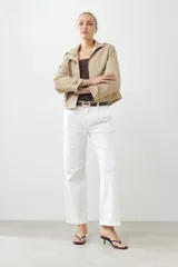 Pantalón wide leg color crudo con pinzas delanteras y cierre con botón y cremallera.