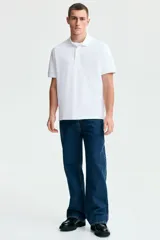 Remera polo blanca de manga corta en piqué de algodón, con cuello clásico y tapeta de dos botones.