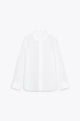 Camisa blanca de lino 100%, con cuello solapa, manga larga con puño y cierre frontal con botones.