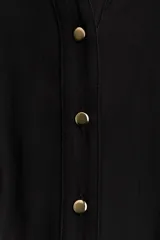 Vestido camisero midi de color negro, corte holgado con cuello, escote en V y cierre frontal de botones. Cuenta con mangas largas con puños anchos y un cinturón ajustable para anudar en la cintura.