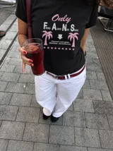Remera blanca de manga corta, con cuello redondo y diseño gráfico estampado en el pecho que incluye texto y palmeras.