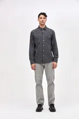 Camisa de corte regular fit confeccionada en algodón, con estampado de cuadros, cuello solapa clásico, cierre frontal con botones y dos bolsillos en el pecho.