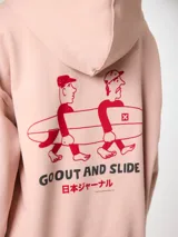 Hoodie de algodón orgánico color rosado con capucha y estampado en la espalda de dos personas cargando una tabla de surf junto al texto "GO OUT AND SLIDE" y caracteres en japonés.