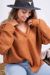 Sweater de punto color marrón con cuello en V y mangas largas.