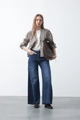 Jean de calce ultra wide confeccionado en denim de algodón color negro. Presenta una silueta amplia desde la cadera y un panel lateral en contraste que estiliza la pierna.