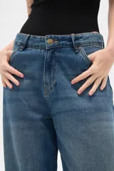 Pantalon jean de corte barrel y tiro medio, en color negro, con diseño de pierna ancha y estructura rígida.