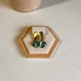 Aros colgantes con base dorada y dije de nácar irregular color verde azulado.