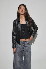 Chaqueta de cuero sintético negro con cierre frontal, cuello clásico y bolsillos laterales.