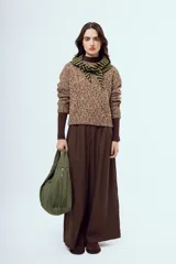 Sweater tejido de punto con acabado moteado en tonos marrones y blancos, de silueta relajada, manga larga y cuello redondo.