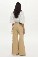 Camisa blanca de algodón con mangas abullonadas, cuello camisero y bordados geométricos y florales en tonos celestes y amarillos en el frente y las mangas.
