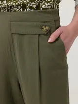 Pantalón de corte recto y tiro alto, confeccionado en una mezcla de lino y viscosa. Presenta un diseño con pinzas frontales y un detalle de botón lateral en la cintura.