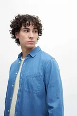 Camisa de manga larga celeste de denim con bolsillo en el pecho.