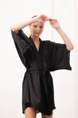 Bata corta de seda negra con mangas amplias estilo kimono y lazo ajustable en la cintura.