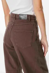 Jean de corte recto y tiro alto, color marrón, con bolsillos traseros y etiqueta de cuero sintético con logo de la marca en la cintura.