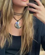 Gargantilla con doble tiento negro y dije de alpaca con forma de luna creciente.