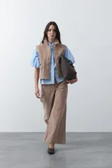 Pantalón de pana de corte wide leg, con diseño de silueta amplia y relajada. Presenta bolsillos frontales con detalles bordados y cierre de botón metálico.