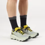 Championes de trail running Salomon Ultra Flow 2, de color negro con suela blanca y detalles en gris. Cuenta con upper de malla transpirable, entresuela amortiguada y suela con tacos para mayor tracción en terrenos difíciles.