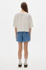 Remera color crudo de algodón lavado, corte cropped y mangas cortas. Presenta un pequeño bordado con las iniciales "PS" en el pecho.