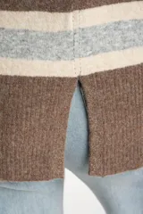 Polera de tejido de punto con diseño a rayas horizontales en tonos marrón, beige y gris. Presenta cuello alto, mangas largas con puños anchos y un corte holgado.
