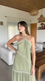 Vestido largo de gasa color verde sage, con escote halter y espalda regulable. Presenta detalles de volados fruncidos en diagonal a lo largo del diseño.