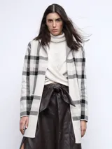 Falda midi marrón de cuero sintético, corte evasé, con abertura lateral y lazo en la cintura.