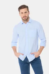 Camisa celeste de lino de manga larga con bolsillo en el pecho y botones personalizados.