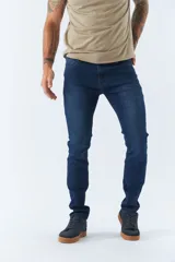 Jean de corte regular para hombre, en color azul oscuro con efecto lavado. Presenta diseño clásico de cinco bolsillos, cierre frontal con botón y cremallera, y trabillas para cinturón.