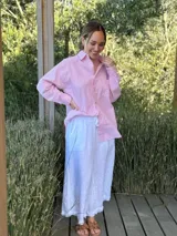 Camisa celeste a rayas verticales blancas, de corte holgado, manga larga y cuello camisero.