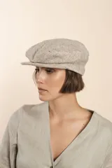 Boina con visera de lana fina uruguaya natural, sin teñir, con diseño de tejido texturizado en tonos beige y marrón.