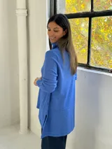 Sweater de punto color azul, con cuello alto acanalado, mangas largas y diseño holgado con costuras verticales decorativas.