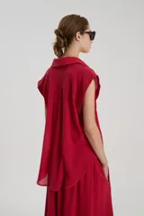 Camisa sin mangas de bambula de algodón color rojo, con cuello camisero, detalle de alforzas en el delantero y cartera de botones frontal.