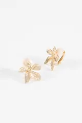 Caravanas metálicas con diseño de flor de cinco pétalos con textura estriada y cierre tipo clip.