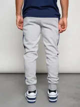 Pantalón de jogging azul marino de felpa con corte ajustado y banda lateral gris.