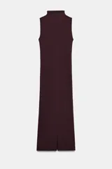 Vestido midi de color negro, con cuello subido y diseño sin mangas. Presenta un detalle de drapeado lateral en la parte delantera y cierre de cremallera oculta en la espalda.