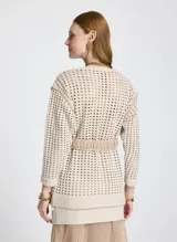 Sweater de punto calado color beige, con escote redondo y mangas 3/4. Incluye cinto de soga con hebilla redonda de madera.