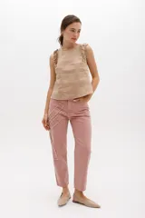 Jean gris lavado, estilo mom fit, con aplique fruncido en forma de espiral en la pierna izquierda, tiro alto, bolsillos delanteros y traseros funcionales, y cierre frontal con botón y cremallera.