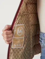 Campera puffer Michael Kors de color blanco, con diseño acolchado, cierre frontal metálico, bolsillos laterales con cierre y capucha desmontable. Incluye bolsa autoportante para guardado.