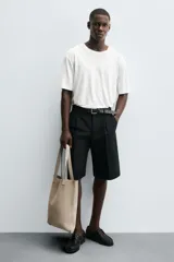 Bolso tipo shopper fabricado en cuero con acabado serraje color gris oscuro. Compartimento principal sin cierre con bolsillo interior con cremallera. Dos asas de mano fabricadas en cuero.