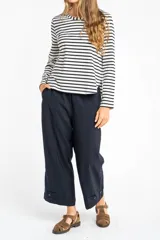 Pantalón ancho azul marino con cintura elástica, bolsillos laterales y detalle de botones en el tobillo.