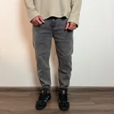 Jean de corte mom al tobillo en color gris con efecto lavado, de tiro medio y ajuste holgado en las piernas.