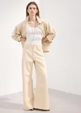 Jeans de corte wide leg y tiro medio, confeccionados en denim 100% algodón de color beige claro, con diseño de perneras amplias y rectas.