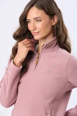 Buzo de polar color crema con cuello alto y cierre frontal parcial. Presenta detalles en cuero en el tirador del cierre y un pequeño bordado en el pecho y en la manga.