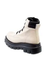 Borcego de cuero color blanco hueso, estilo militar o de combate, con cordones negros y suela track gruesa de goma negra. Presenta cuello acolchado negro.