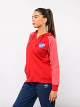 Campera deportiva con capucha y cierre frontal, de la marca Umbro para el Club Nacional de Football. Presenta un diseño en azul marino con mangas en tono gris jaspeado, detalles de vivos tricolores en los hombros y el escudo del club bordado en el pecho.