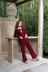 Conjunto bordó de punto, compuesto por un suéter con escote redondo y cierre frontal de lazos y un pantalón largo de corte recto.