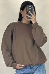 Buzo de cuello redondo, corte oversize, con mangas largas y puños elásticos.