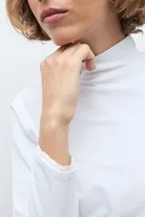 Remera de manga larga con detalle de puntilla en los puños, confeccionada en tejido suave y elástico.