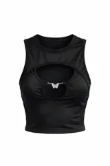Remera corta sin mangas color negro, con diseño de abertura frontal tipo cut-out en el pecho y detalle de dije metálico en forma de mariposa que une la abertura.